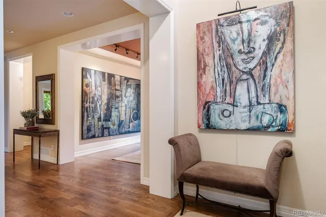 a living room with furniture and a painting on the wall