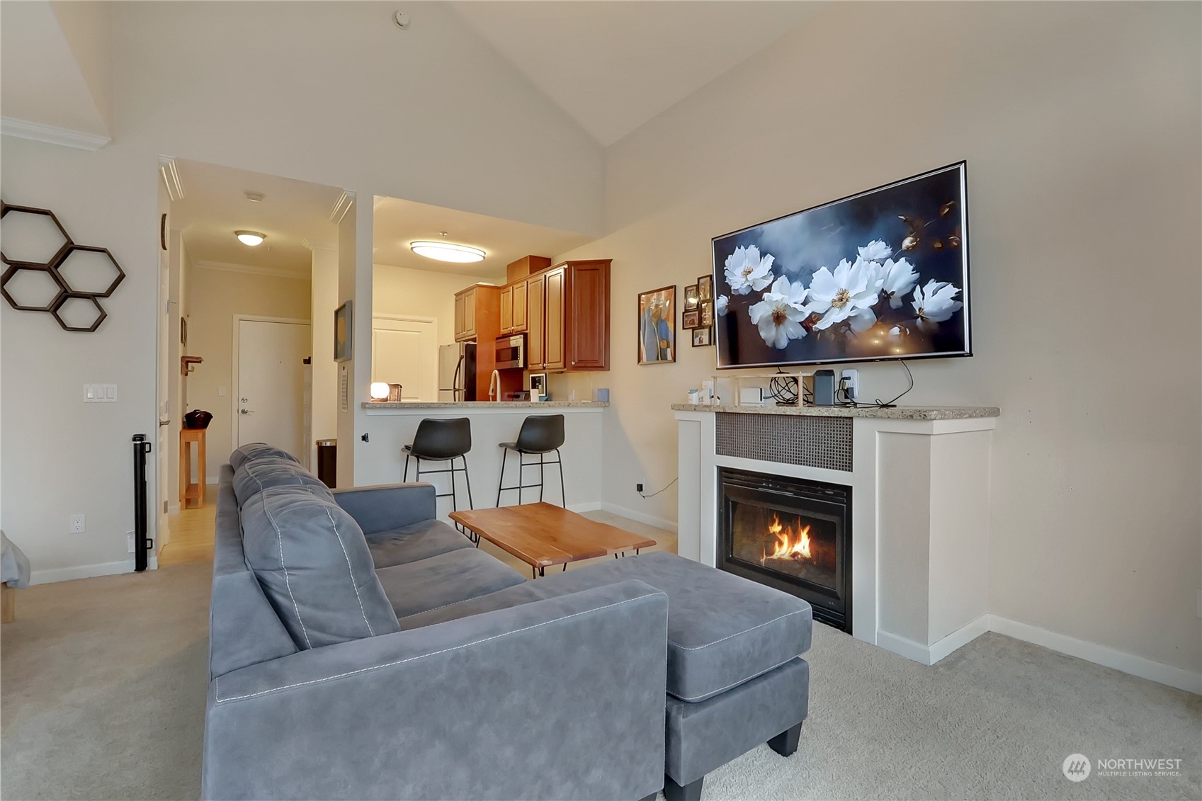 225 Logan Avenue South, Unit 307 Renton, WA 98057 - Photo 18 of 23 a living room with furniture a fireplace and a flat screen tv