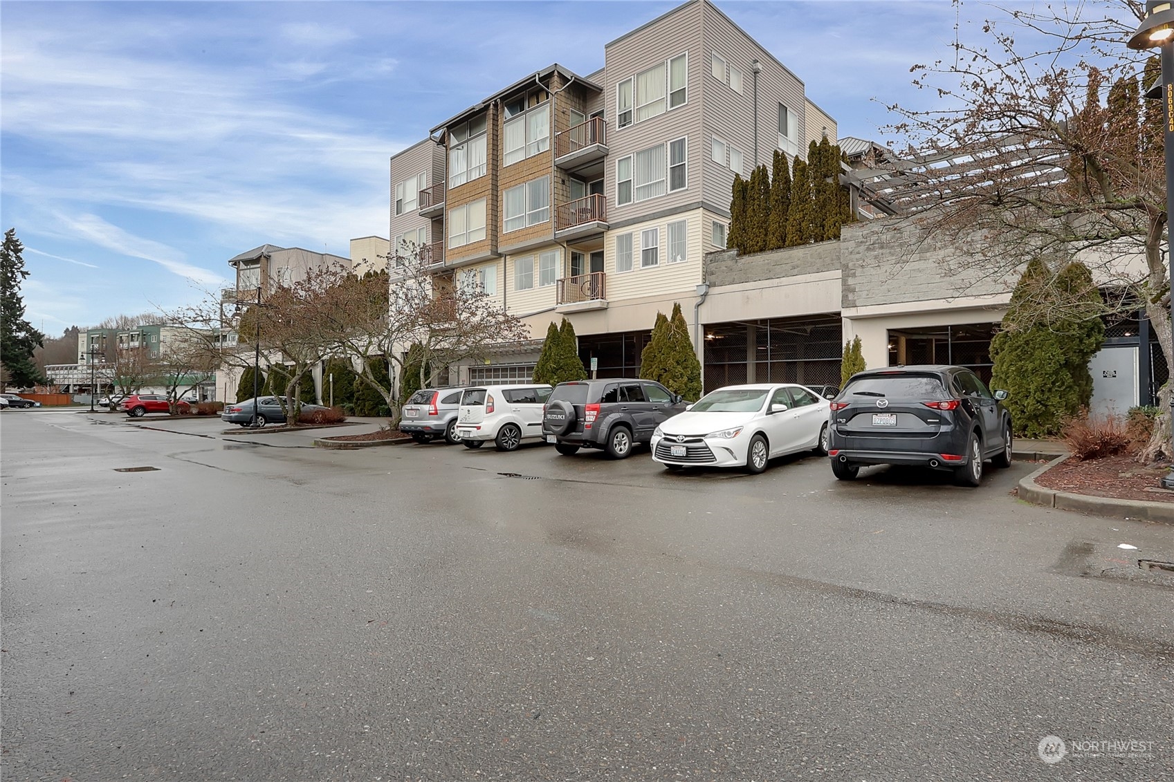 225 Logan Avenue South, Unit 307 Renton, WA 98057 - Photo 3 of 23 a view of road with card parked on side and retail shops