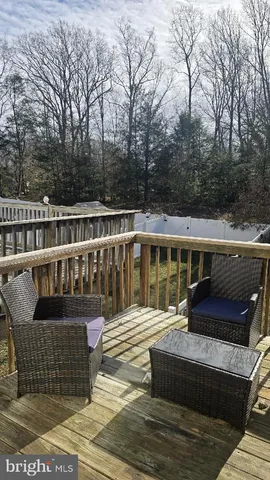 a view of a backyard with large trees and wooden fence