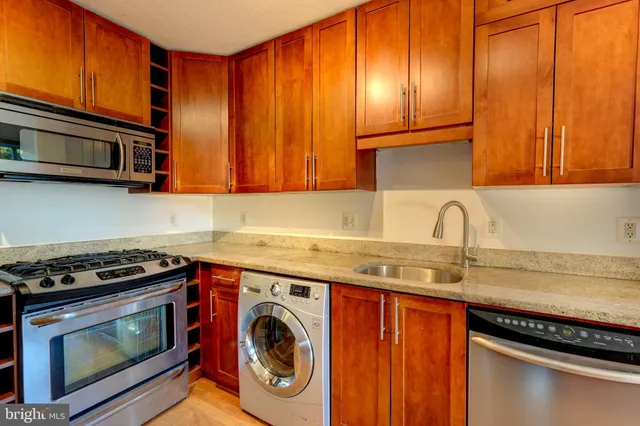 a kitchen with stainless steel appliances granite countertop a stove a sink and dishwasher