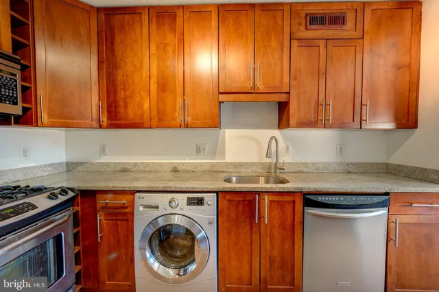 a kitchen with granite countertop cabinets stainless steel appliances and a sink