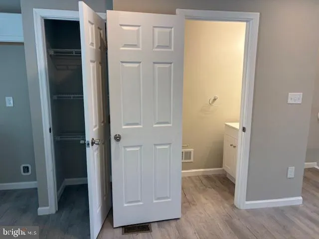 a kitchen with kitchen island granite countertop a stove a sink a center island and wooden floor