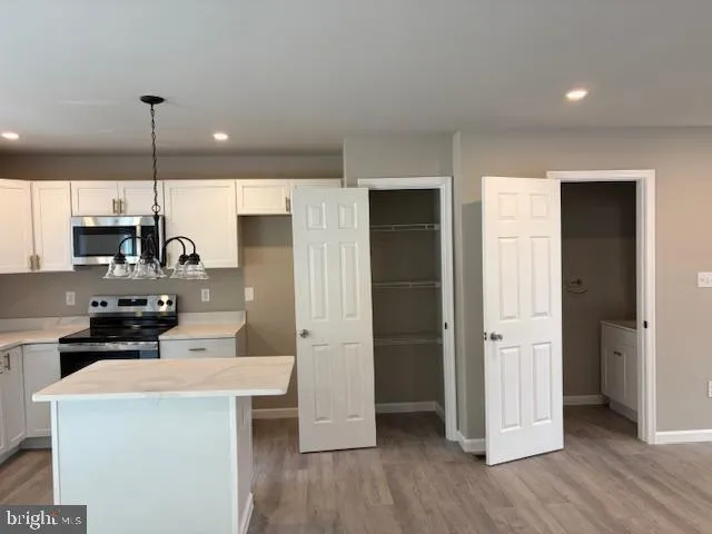 a kitchen with stainless steel appliances a refrigerator a sink a stove a microwave and island