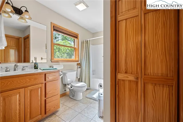 a living room with furniture a red lamp and a wooden floor
