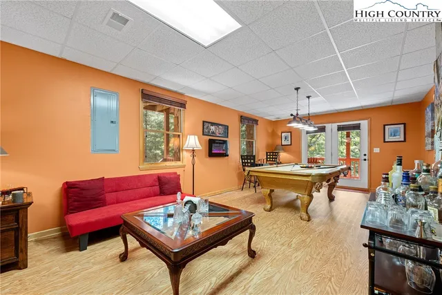 a dining room with stainless steel appliances granite countertop a sink a stove and chairs with wooden floor