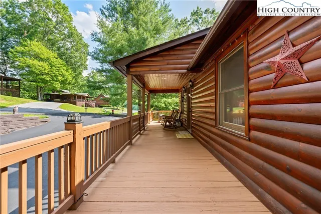 a view of a patio with table and chairs with wooden floor and fence