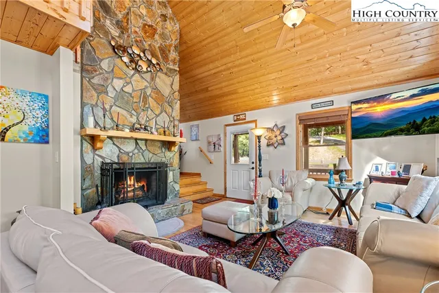 a living room with furniture a table and a large window