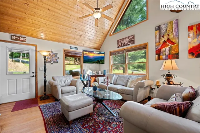 a dining room with furniture large windows and a chandelier