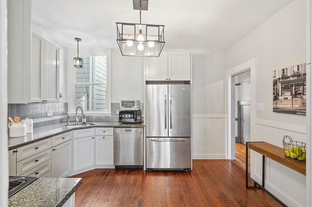 a kitchen with appliances cabinets a sink and wooden floor