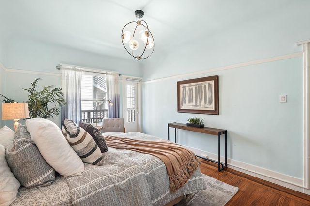 a bedroom with a large bed and a chandelier