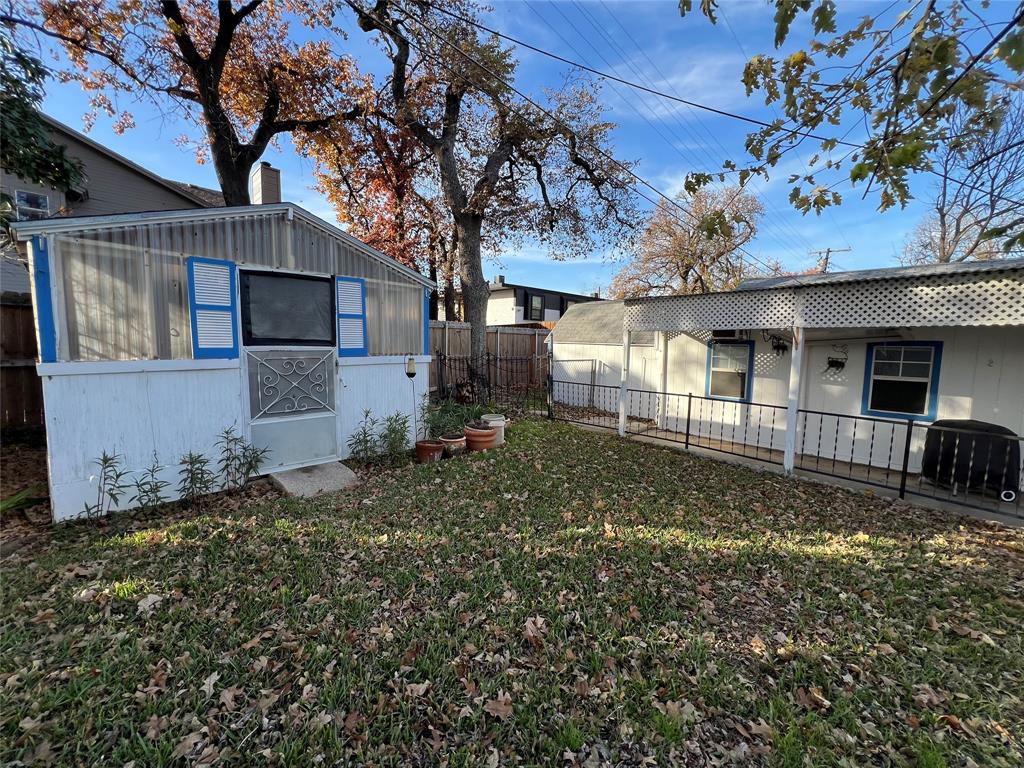 909 Rindie Street Irving, TX 75060 - Photo 16 of 18 a view of a house with a large tree and a big yard