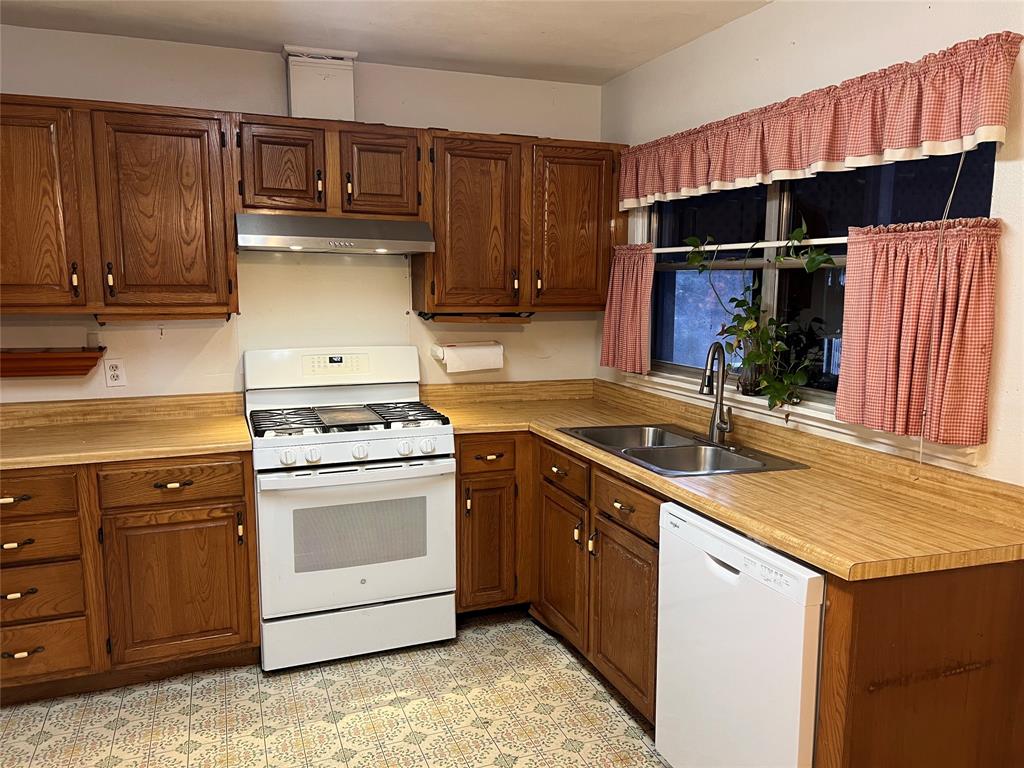 909 Rindie Street Irving, TX 75060 - Photo 7 of 18 a kitchen with stainless steel appliances granite countertop a sink stove and cabinets