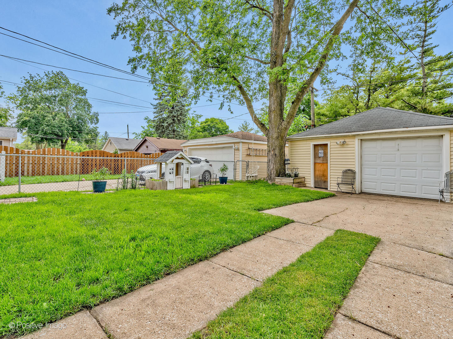4154 Elm Avenue Brookfield, IL 60513 - Photo 19 of 20 a view of a white house in front of a yard with plants and large trees