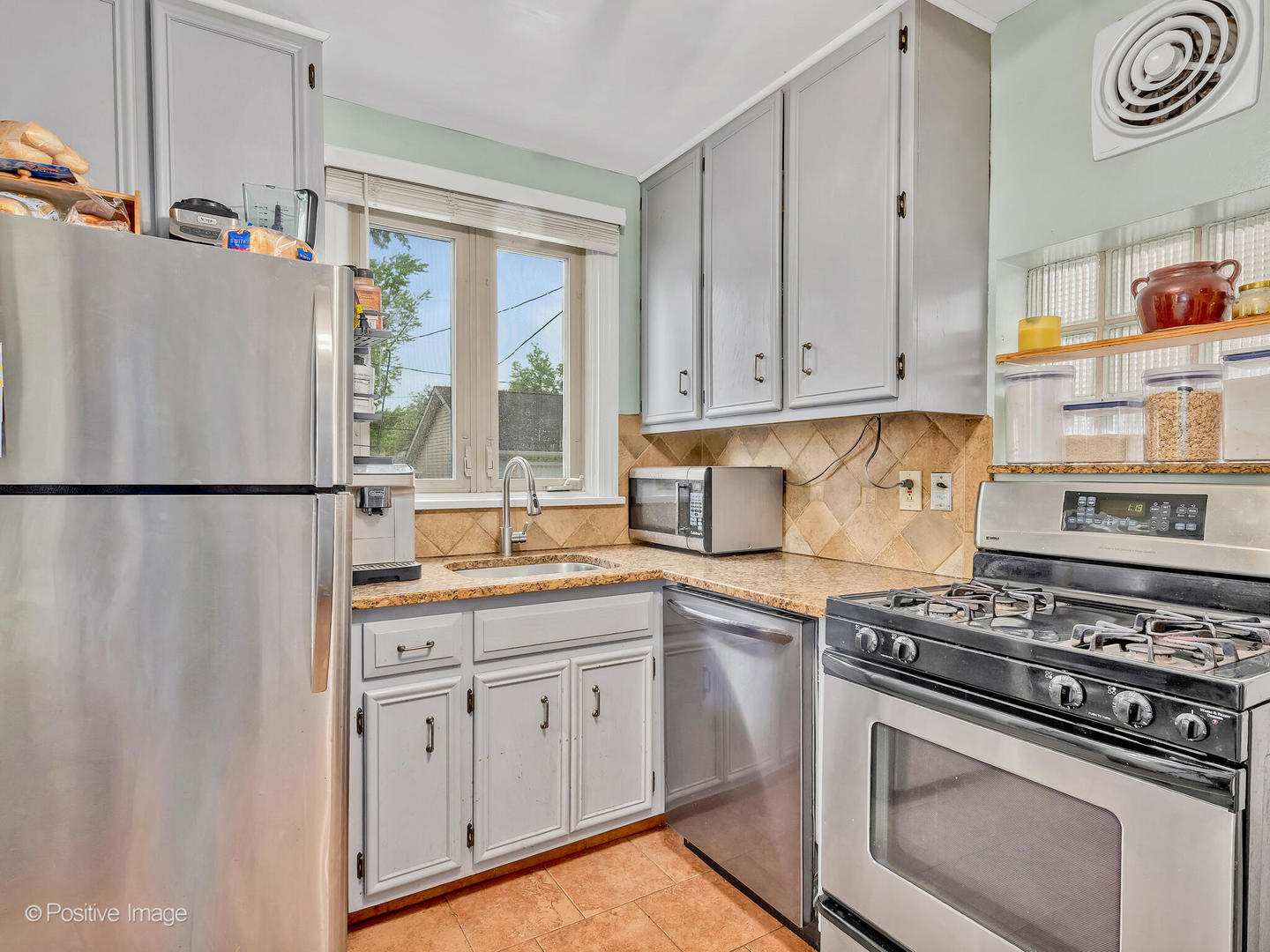 4154 Elm Avenue Brookfield, IL 60513 - Photo 5 of 20 a kitchen with stainless steel appliances white cabinets and a stove top oven