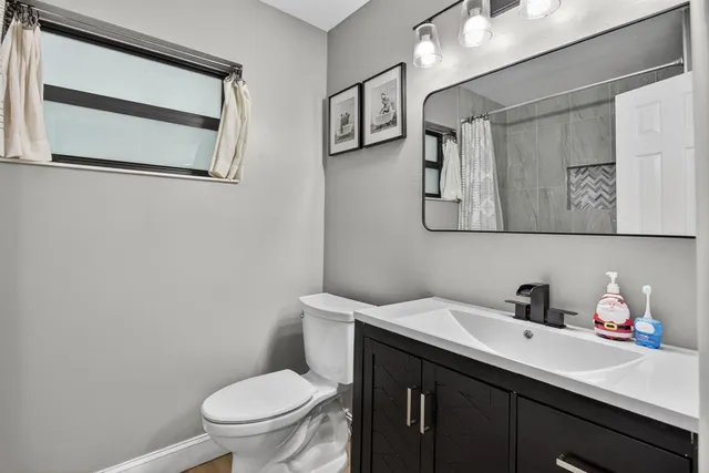 a bathroom with a toilet sink and mirror