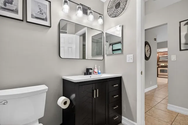 a bathroom with a toilet sink vanity and mirror
