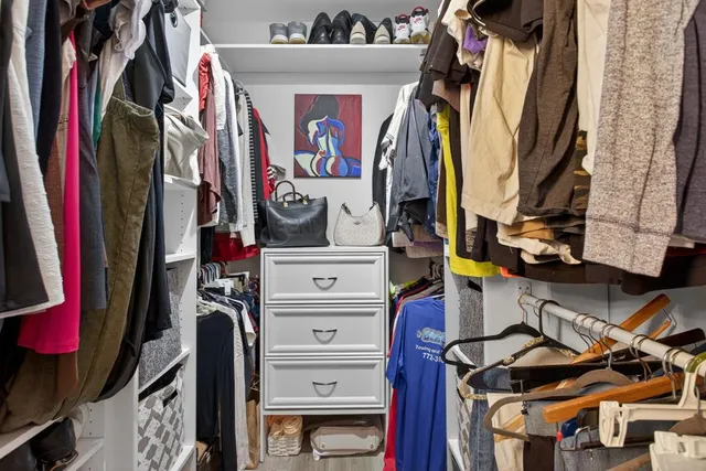 a view of walk in closet with clothes and shoes