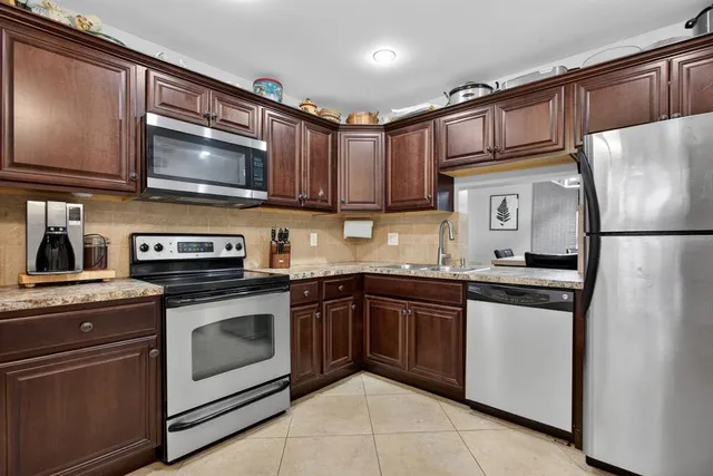 a kitchen with stainless steel appliances granite countertop a stove microwave and refrigerator