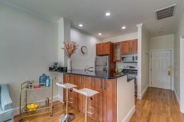 a kitchen with stainless steel appliances kitchen island granite countertop a refrigerator and a stove top oven
