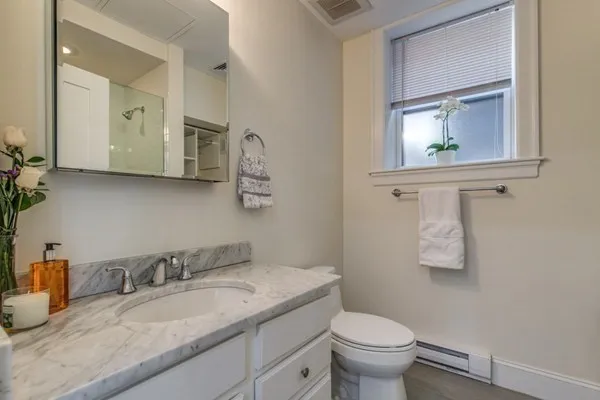 a bathroom with a granite countertop toilet a sink and a mirror