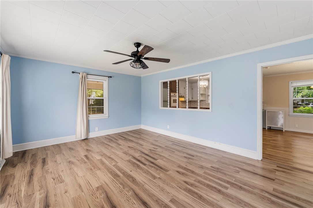 12 Dendy Street Pelzer, SC 29669 - Photo 3 of 31 A spacious room features beautiful wood-look flooring and a ceiling fan for comfort.