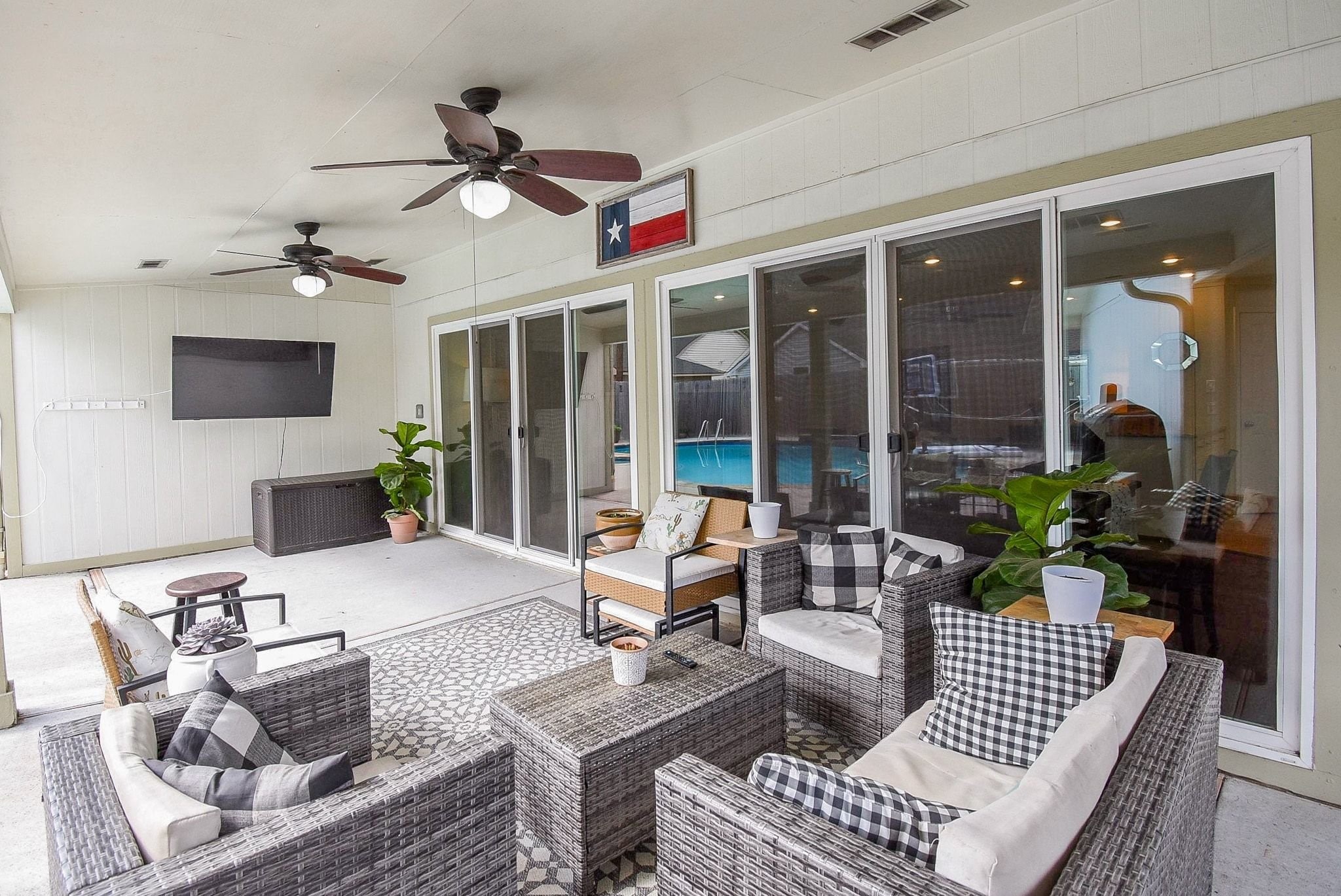 2930 Kevin Lane Houston, TX 77080 - Photo 2 of 50 This inviting outdoor patio features ceiling fans for comfort. Large sliding glass doors open to a view of the pool, seamlessly blending indoor and outdoor living. Perfect for relaxation and gatherings.