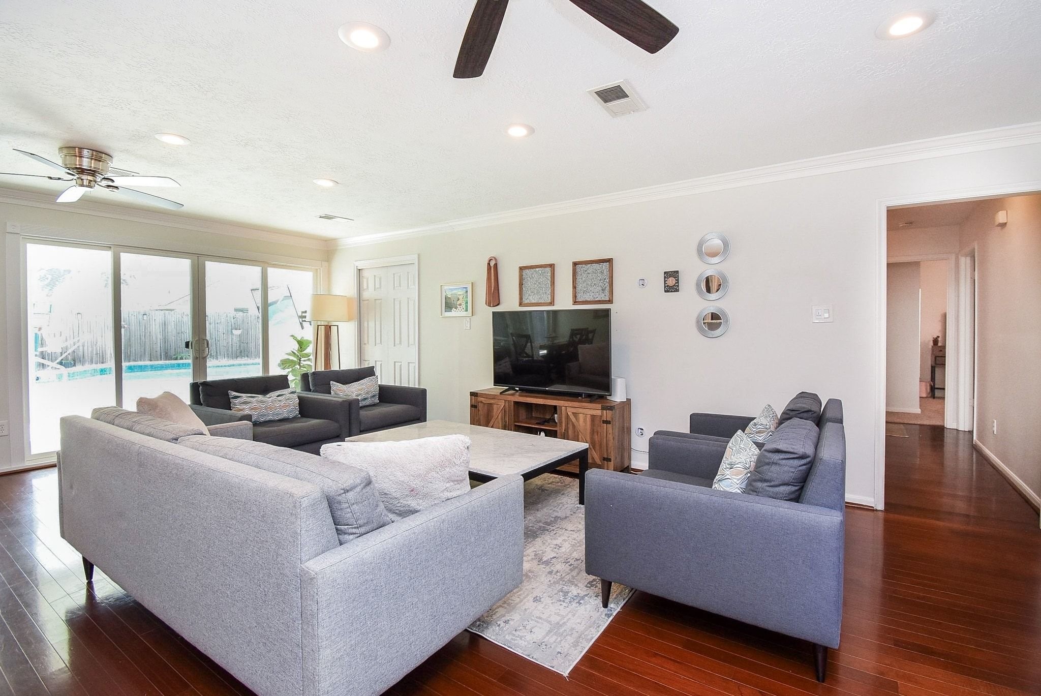2930 Kevin Lane Houston, TX 77080 - Photo 23 of 50 This spacious family room features wood flooring, recessed lighting, and a ceiling fan. Sliding glass doors provide natural light and a view of the pool outside.