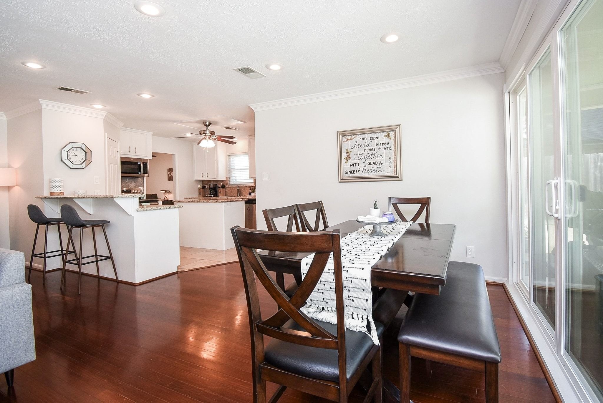 2930 Kevin Lane Houston, TX 77080 - Photo 26 of 50 This open-plan dining and kitchen area features hardwood floors, a cozy and a kitchen with a breakfast bar, granite countertops, and modern appliances. Large sliding glass doors provide ample natural light.