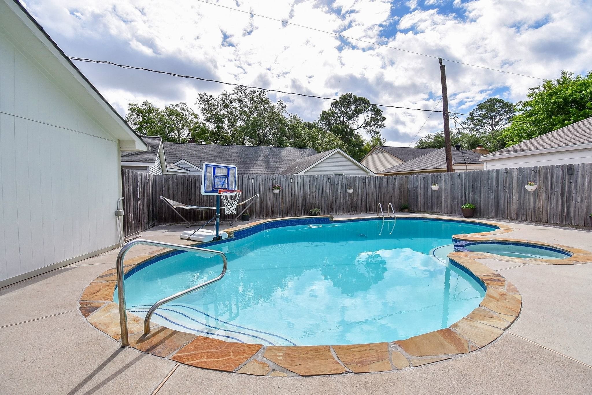 2930 Kevin Lane Houston, TX 77080 - Photo 3 of 50 This backyard features a private pool with a stone border and a wooden fence for privacy. Ideal for relaxation and entertaining.