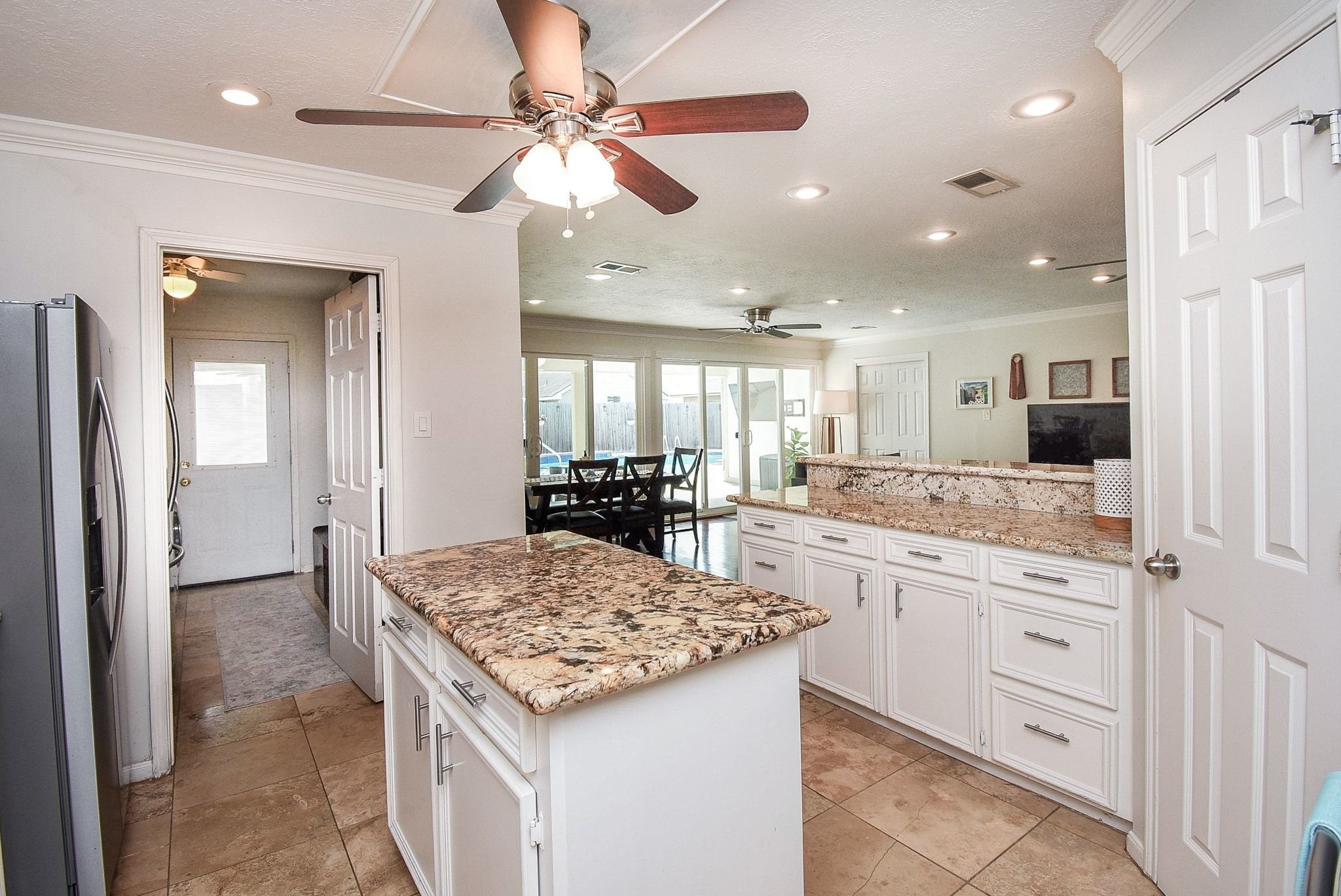 2930 Kevin Lane Houston, TX 77080 - Photo 31 of 50 This spacious kitchen features elegant granite countertops, ample white cabinetry, and modern stainless steel appliances. It opens to a bright living area with large windows and a dining space, creating an inviting and functional layout.