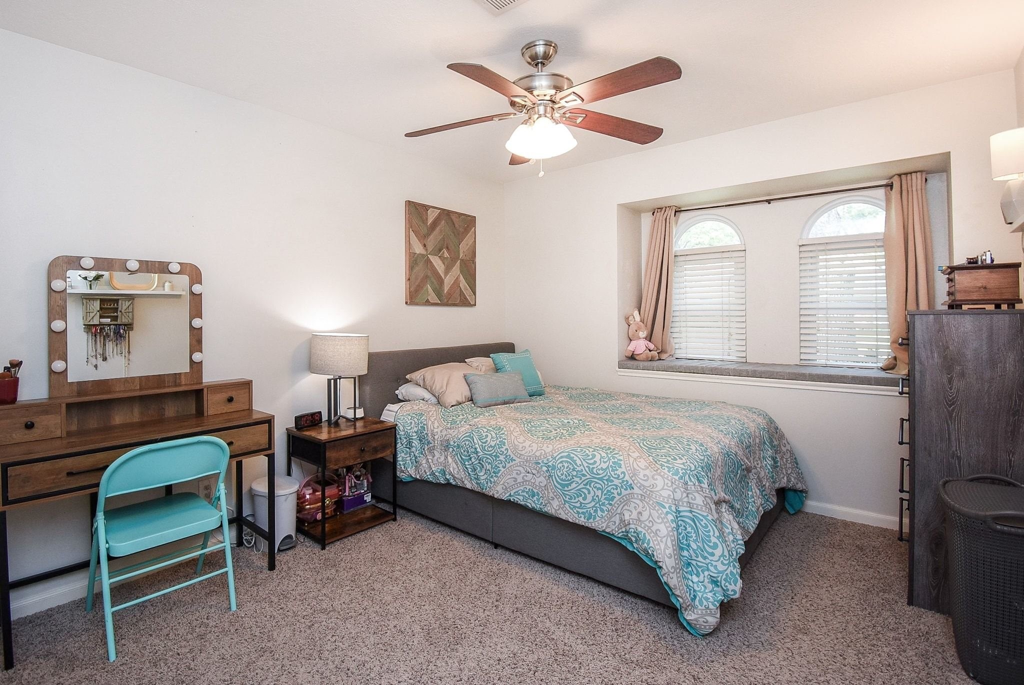 2930 Kevin Lane Houston, TX 77080 - Photo 39 of 50 Cozy bedroom with neutral walls and carpet, featuring a ceiling fan. It has a double window with seating.