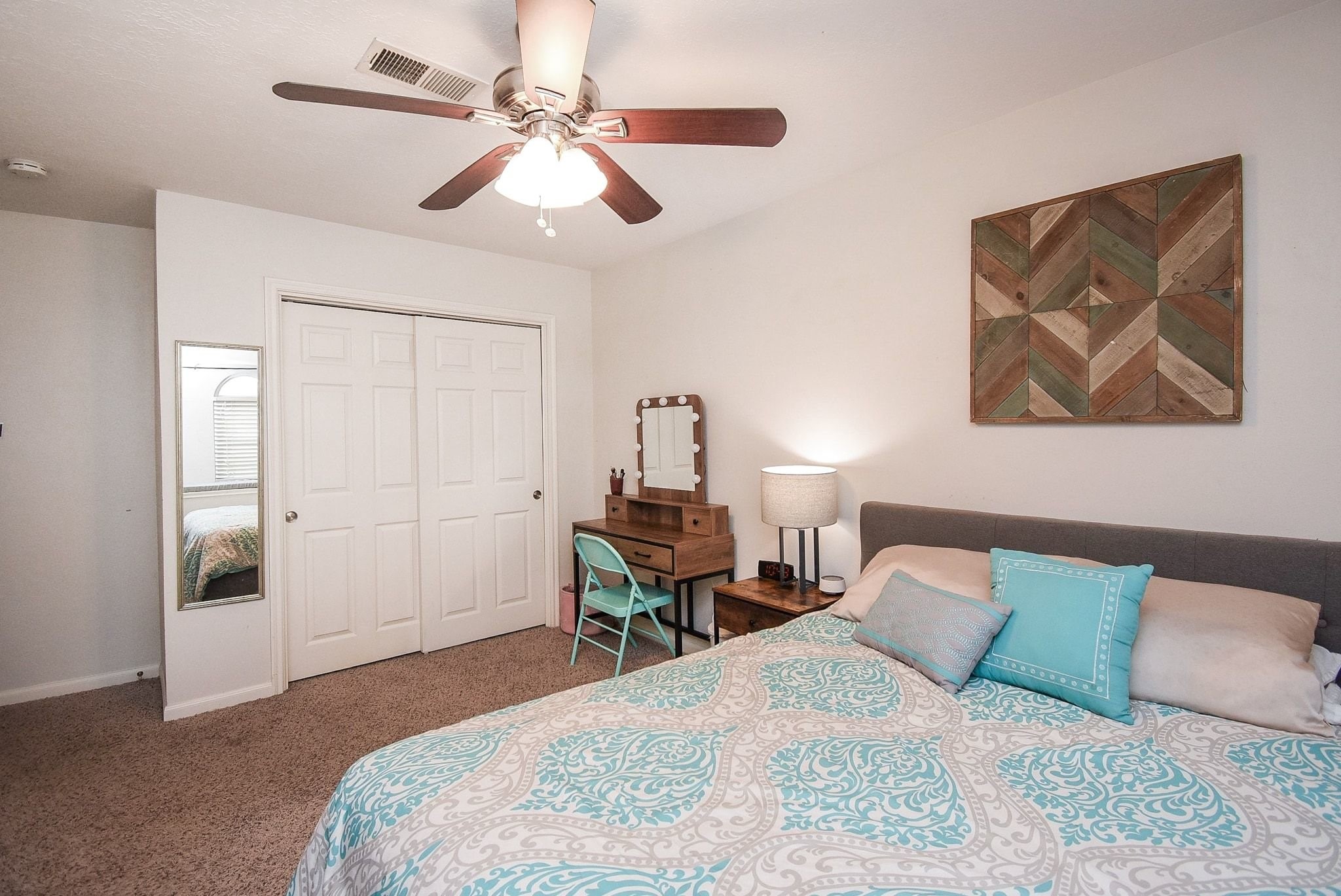 2930 Kevin Lane Houston, TX 77080 - Photo 40 of 50 This cozy bedroom features a ceiling fan, soft carpeted floors, and a stylish accent wall. It includes a spacious closet with sliding doors. The room is well-lit and inviting.