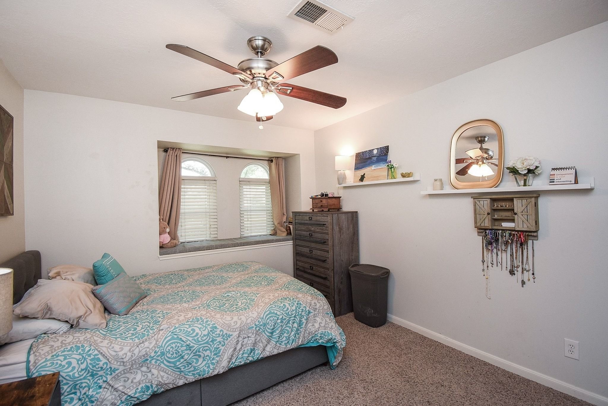 2930 Kevin Lane Houston, TX 77080 - Photo 41 of 50 Cozy bedroom with neutral walls, featuring a ceiling fan and soft carpet. A large window with shutters offers natural light.