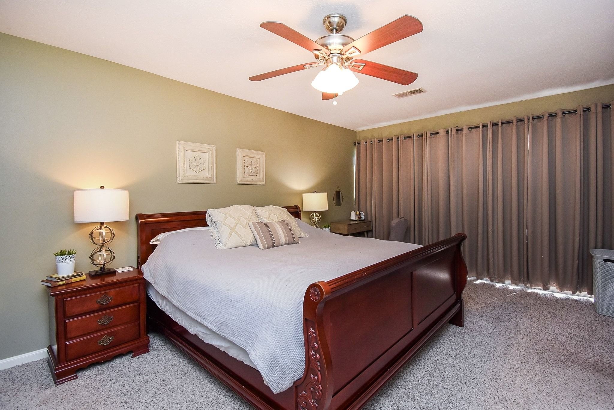 2930 Kevin Lane Houston, TX 77080 - Photo 43 of 50 Spacious bedroom with a warm, inviting atmosphere. Features neutral painted walls, carpeted flooring, ceiling fan, and black out curtains on the large windows. Ideal for comfort and relaxation.