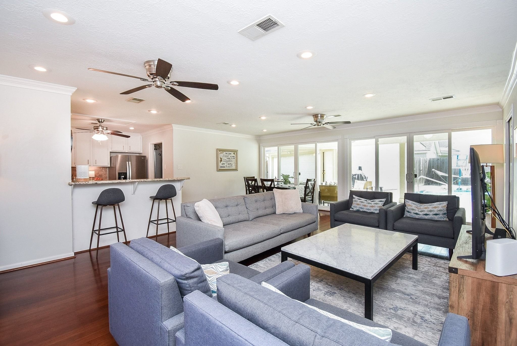 2930 Kevin Lane Houston, TX 77080 - Photo 5 of 50 This spacious living area features an open layout with ample natural light from sliding glass doors. The room flows into a kitchen with a breakfast bar and stainless steel appliances, perfect for entertaining.