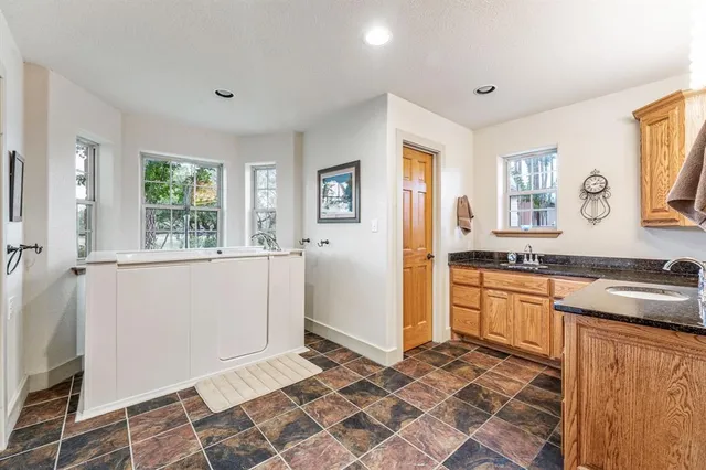 a kitchen with granite countertop a refrigerator and a stove top oven