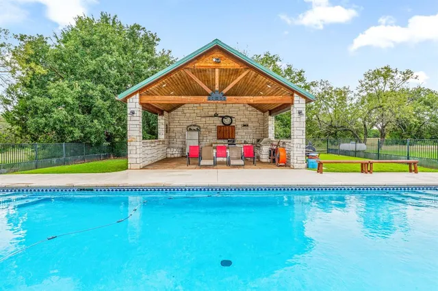 a view of pool with a small yard and swimming pool
