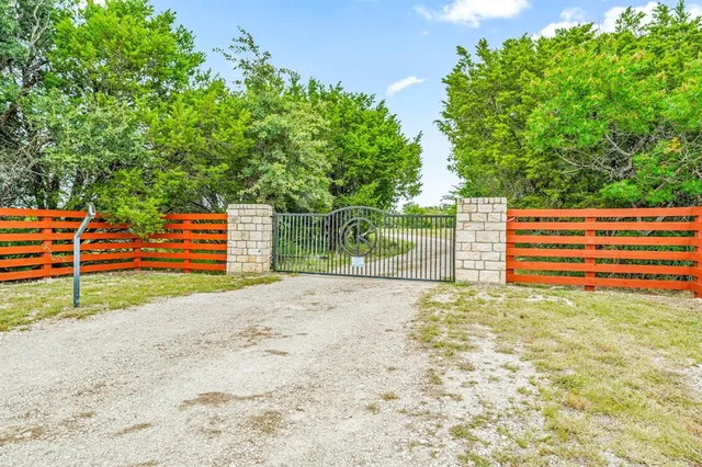 a view of a yard with wooden fence