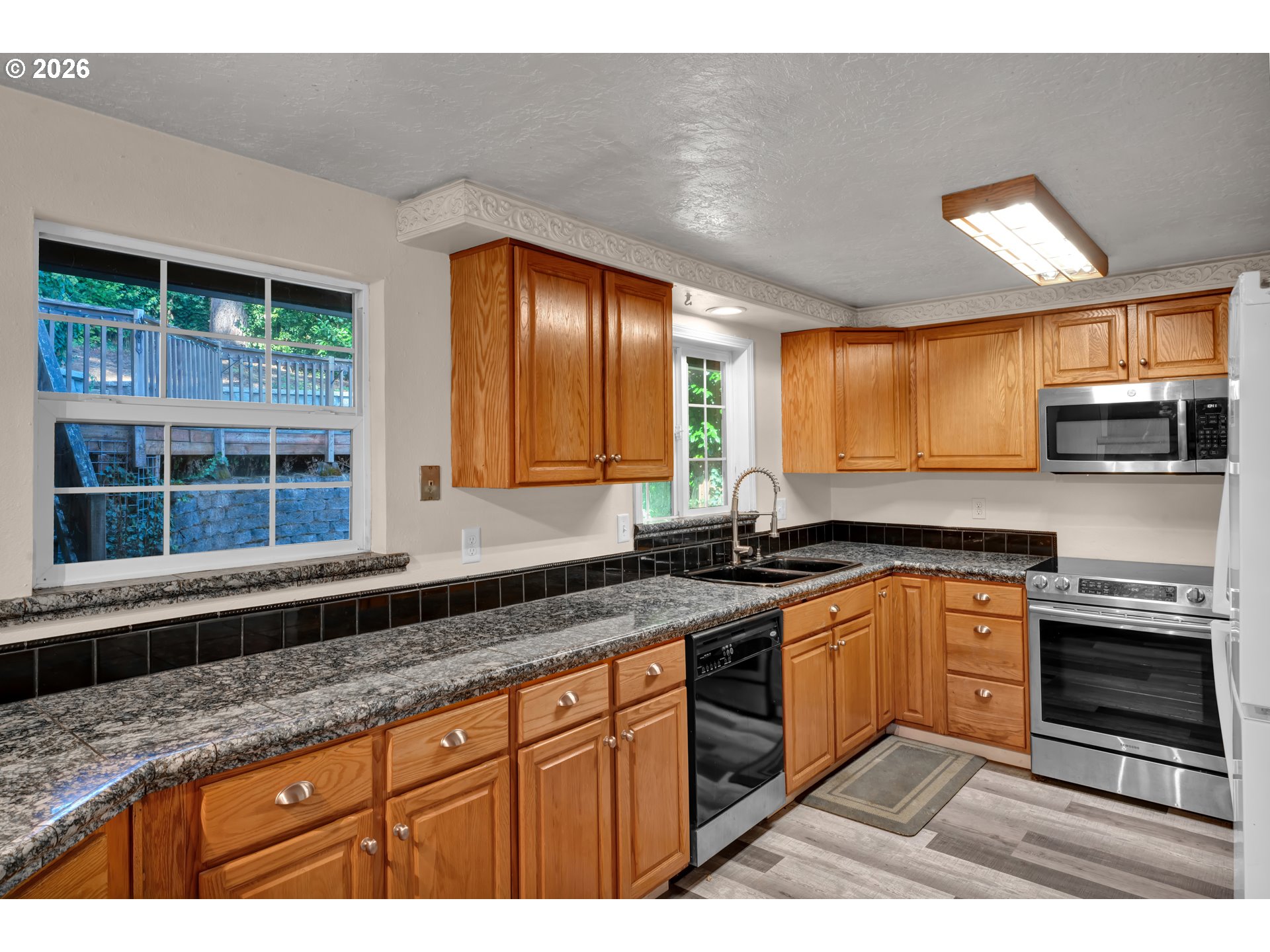 947 South R Street Cottage Grove, OR 97424 - Photo 15 of 48 a kitchen with stainless steel appliances granite countertop a stove a sink and a microwave
