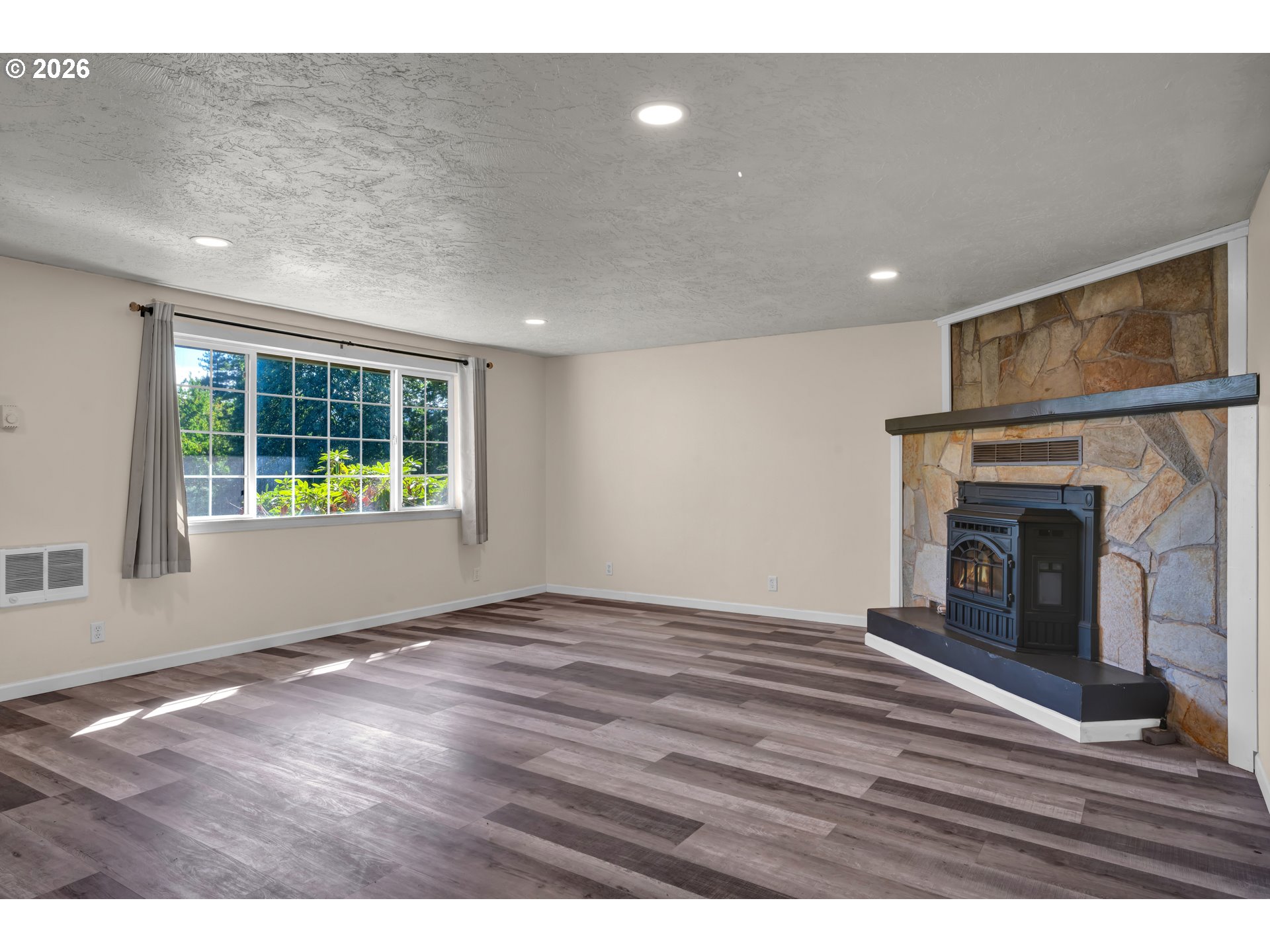 947 South R Street Cottage Grove, OR 97424 - Photo 10 of 48 a view of an empty room with wooden floor fireplace and a window