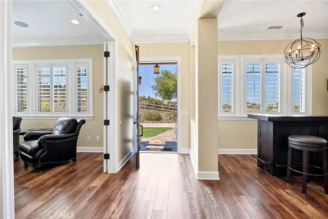 a kitchen with kitchen island granite countertop wooden floors and white cabinets