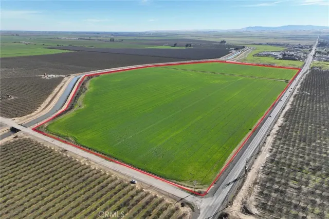 a green field with lots of trees in the background