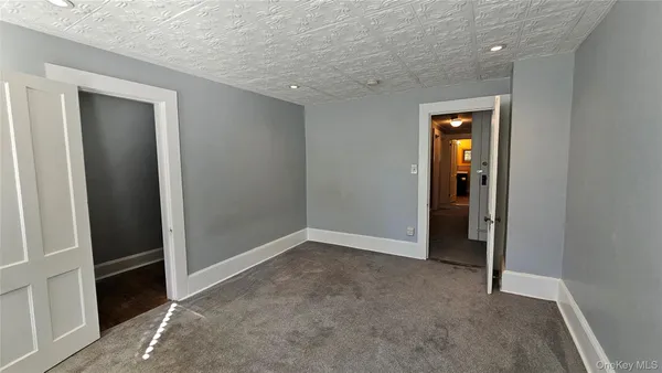 a view of an empty room with wooden floor and window