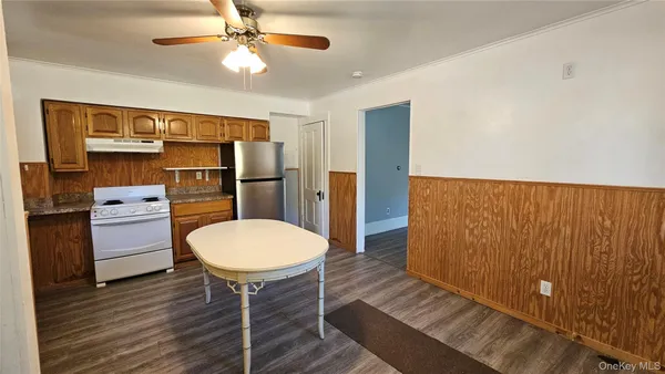 a room with furniture a wooden floor and a ceiling fan