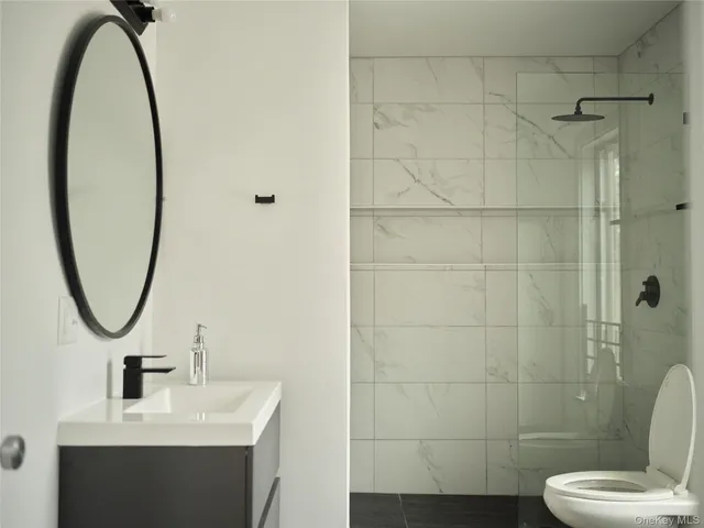 a bathroom with a sink a toilet and a mirror