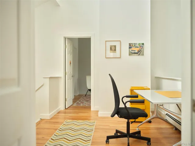 a view of a workspace with furniture and wooden floor