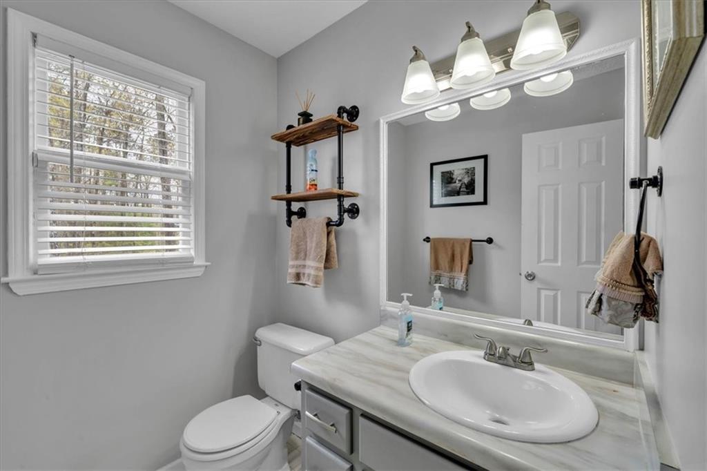 3410 Pilot Road Covington, GA 30014 - Photo 11 of 66 a bathroom with a toilet a sink and mirror