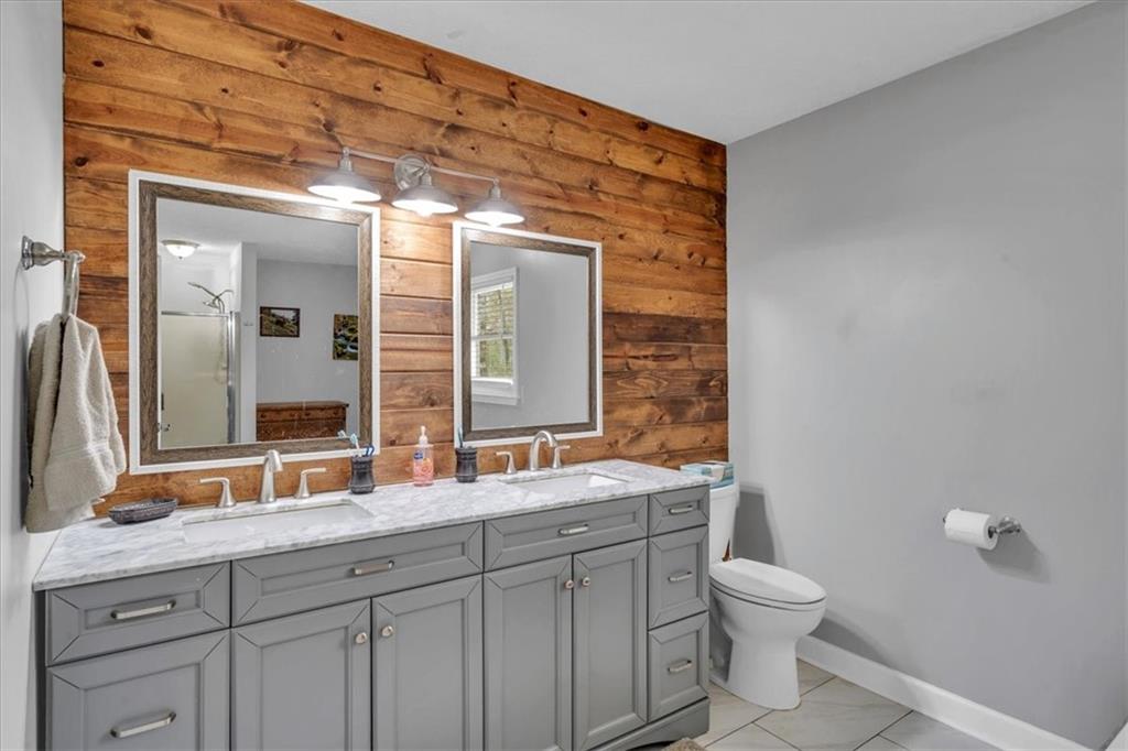 3410 Pilot Road Covington, GA 30014 - Photo 23 of 66 a bathroom with a double vanity sink toilet and mirror