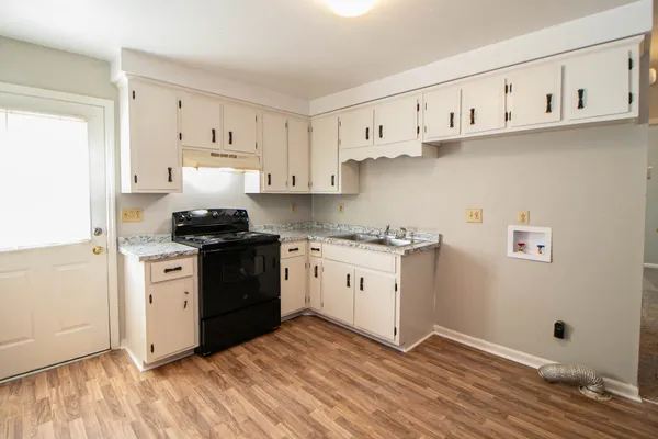 a kitchen with granite countertop white cabinets and white appliances
